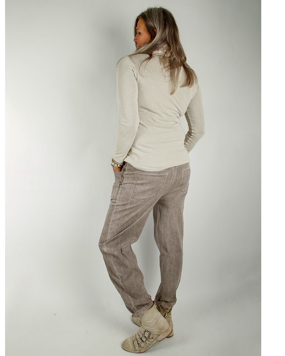 Modell iført Baggy Stretch Pants, Beige – vid, avslappet buksesnitt med elastisk linning i livet