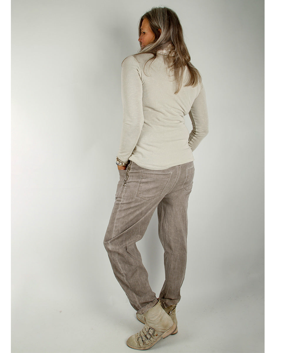 Modell iført Baggy Stretch Pants, Beige – vid, avslappet buksesnitt med elastisk linning i livet